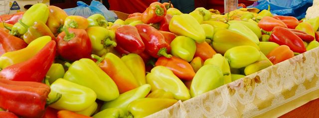 Red and yellow peppers piled high on a market stall