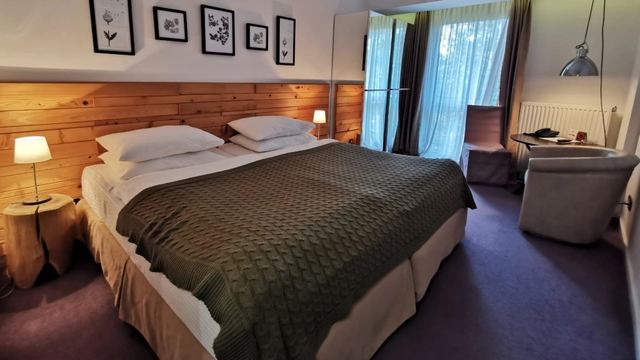 A room at Hotel Palisad with pine panelling and a knitted throw on the bed