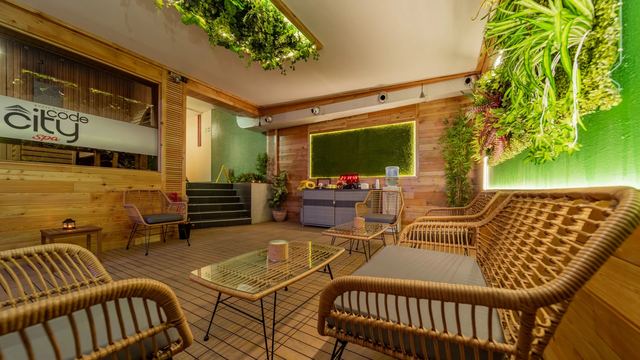 The rattan lounge at City Code Spa, with a living green wall