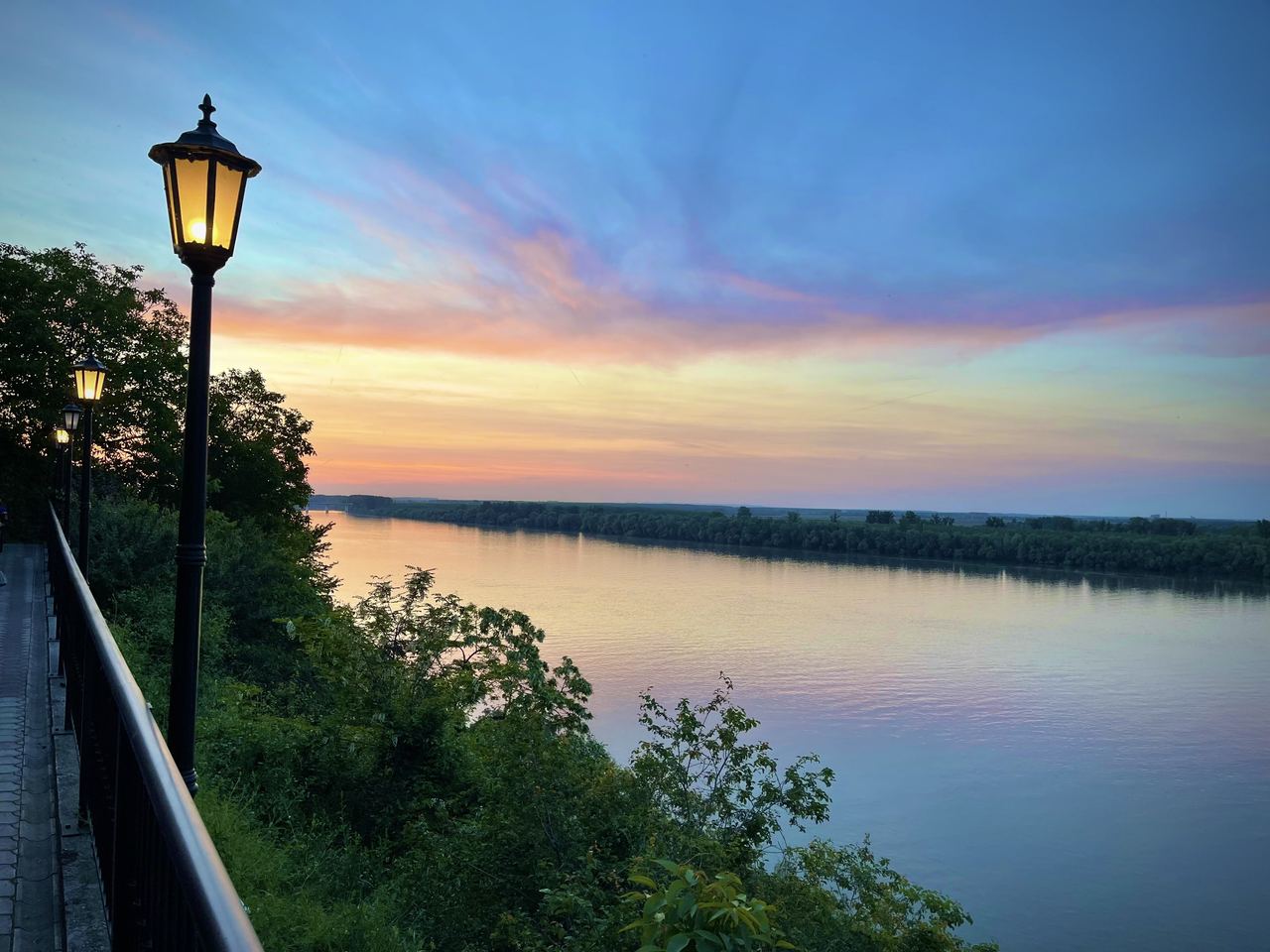 A lamplit riverside path above the Danube in Zemun at sunset